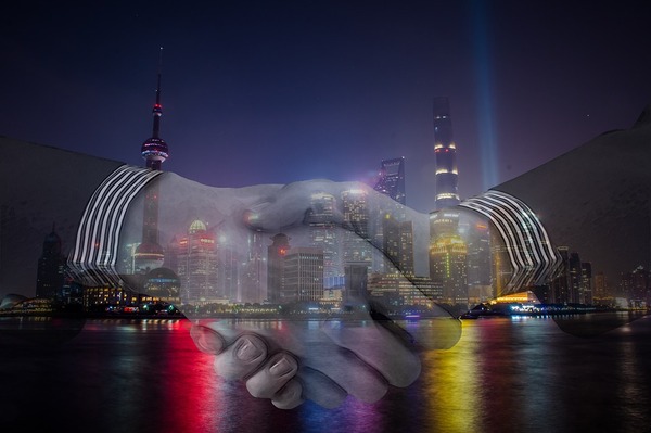 People shaking hands with Shanghai in the background.